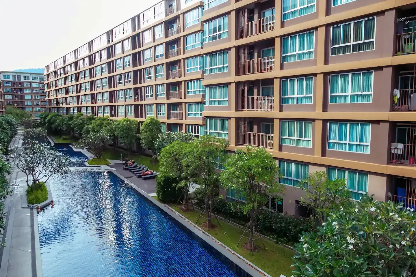 Resort exterior with continuous lagoon swimming pool at D Condo Creek